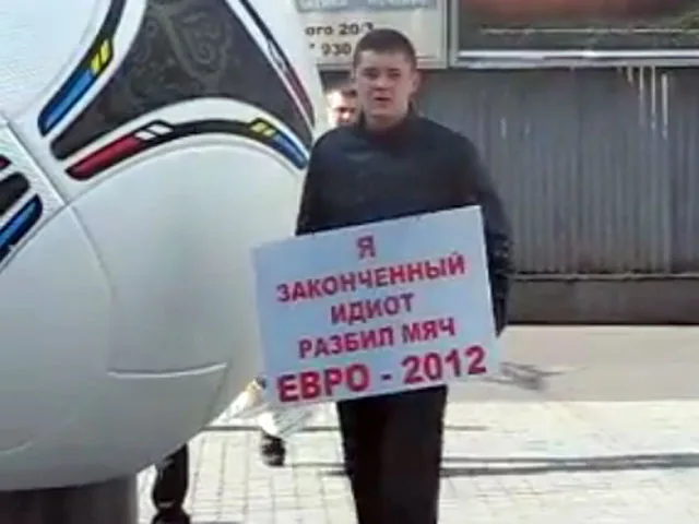 С табличками "Я - идиот", хулиганы, сломавшие мяч Евро-2012, простояли сутки. ВИДЕО