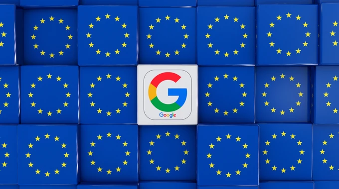 логотип Google на екрані смартфона поруч із прапорами Європейського Союзу