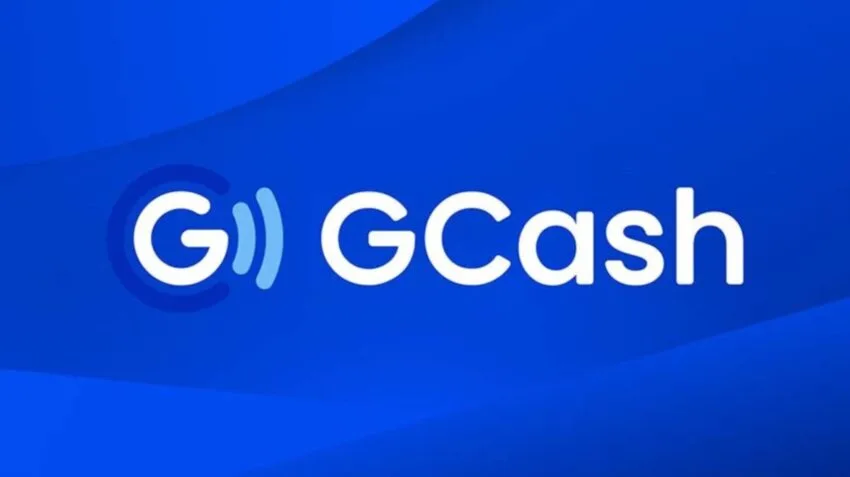 Логотип GCash на смартфоні на тлі біржового табло у Манілі